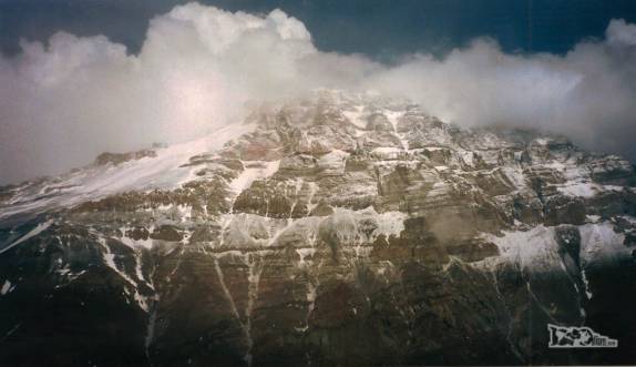 A luz de fim de tarde ilumina a face noroeste do Aconcágua entre nuvens, visto a partir dos 5 mil metros de altitude do Pico do Bonete, em frente à montanha, na região de Mendoza, oeste da Argentina (temporada de 1998/99)